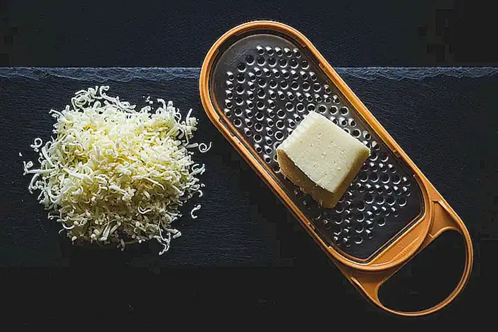 Espolvorea un poco de pan rallado sobre cada ostra y luego agrega un poco de queso parmesano rallado