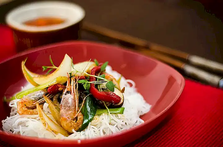 Sirve los camarones caramelizados con arroz blanco y vegetales al vapor