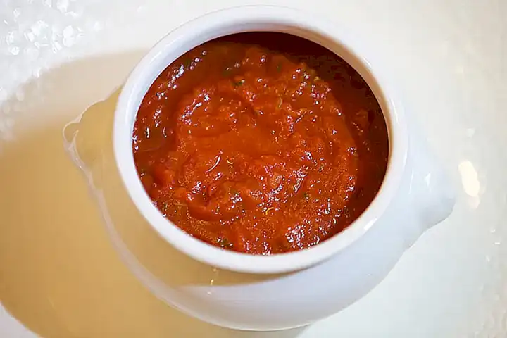 Sirve los mejillones cocidos con la salsa de tomate